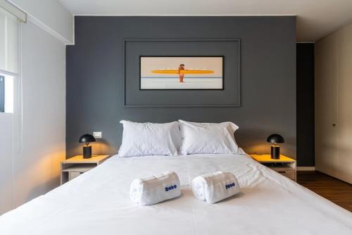 a bedroom with a white bed with a surfboard on the wall at Dubrovnik 2BR by Geko in Lima