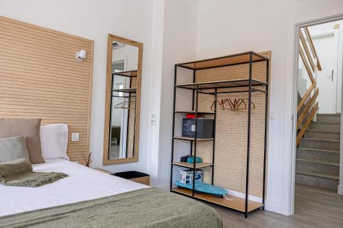 a bedroom with a bed and a mirror and a staircase at Bambú Suites Vegueta Alquiler por Habitación in Las Palmas de Gran Canaria
