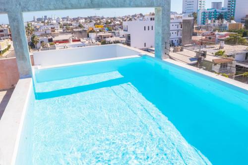 a pool on the roof of a building with a view at Loft a 3 cuadras de la playa by G P S rentas in Mazatlán