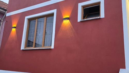 two windows on the side of a red building at Guest House Pogradeci in Pogradec