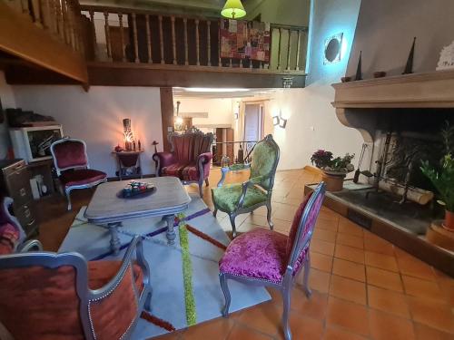 - un salon avec des chaises, une table et une cheminée dans l'établissement Séjour de charme au cœur de la campagne meusienne - FR-1-585-152, à Vouthon-Haut