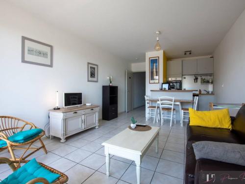 un salon avec un canapé et une table dans l'établissement T2 Balcon Sud à 50m de la Plage - FR-1-825-38, à La Rochelle
