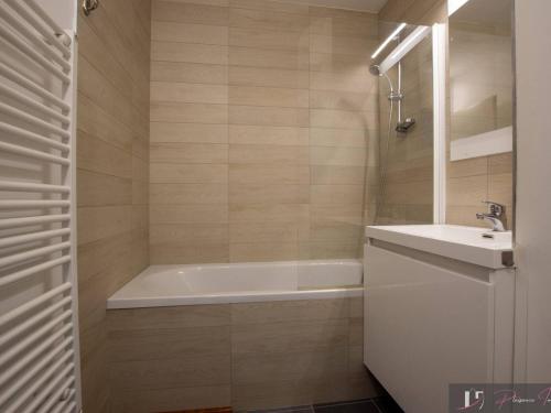 une salle de bain avec une baignoire et un lavabo dans l'établissement T2 Balcon Sud à 50m de la Plage - FR-1-825-38, à La Rochelle