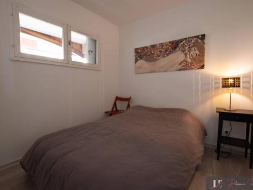 une chambre avec un lit, une fenêtre et un bureau dans l'établissement T2 Balcon Sud à 50m de la Plage - FR-1-825-38, à La Rochelle