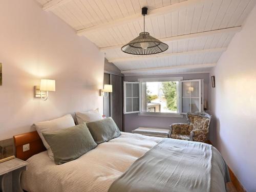 une chambre avec un lit, une chaise et une fenêtre dans l'établissement Charmante Maison de Village au Cœur de La Couarde-sur-Mer - FR-1-434-119, à La Couarde-sur-Mer