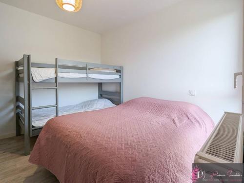- une chambre avec des lits superposés et un couvre-lit rose dans l'établissement Spacieux appartement aux Minimes avec parking près de la plage - FR-1-825-66, à La Rochelle