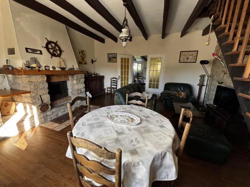 une salle à manger avec une table et une cheminée dans l'établissement Maison 3P Proche Vieux Passage, Animaux Acceptés - FR-1-397-82, à Plouhinec