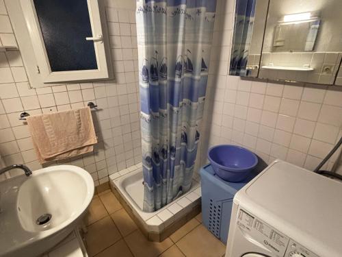 une salle de bain avec un lavabo et un rideau de douche dans l'établissement Maison 3P Proche Vieux Passage, Animaux Acceptés - FR-1-397-82, à Plouhinec