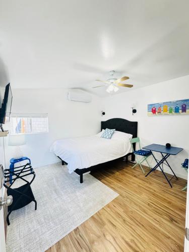 a white bedroom with a bed and a table at Cozy Guesthouse - 15 Min to Downtown SD in Chula Vista