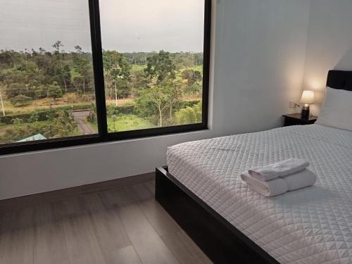 a bedroom with a bed with two towels on it at Finca Procel in Palora