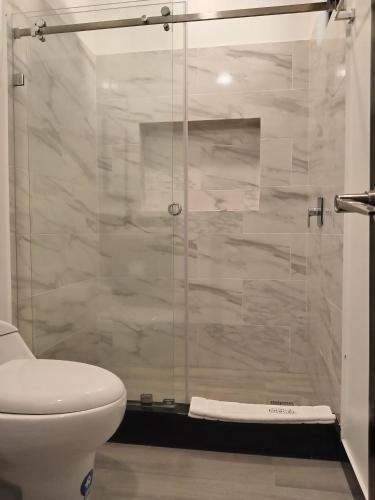 a bathroom with a toilet and a glass shower at Finca Procel in Palora