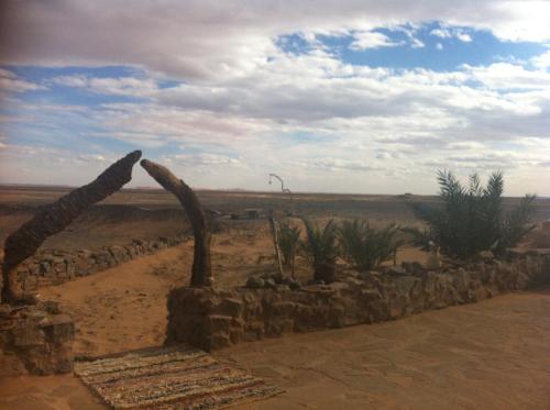 a stone wall in the middle of a desert at Maison Boutchrafine in Erfoud