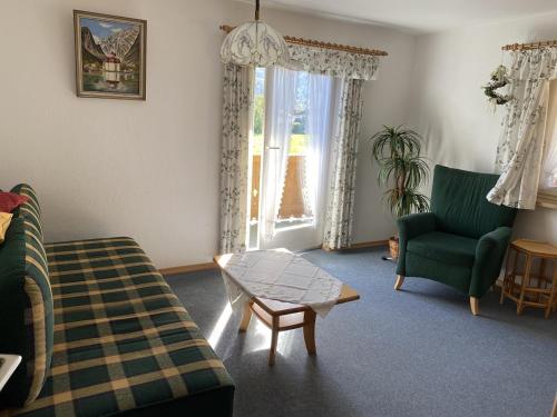 un salon avec un canapé, un fauteuil et une table dans l'établissement Ferienwohnung Kahlersberg, à Schönau am Königssee