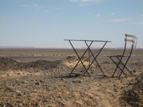 a table and two chairs sitting in the desert at Maison Boutchrafine in Erfoud