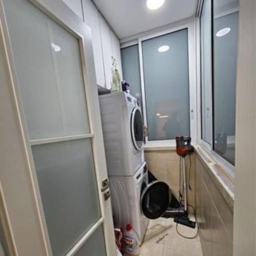 a kitchen with a washing machine and a window at דירת 3 חדרים עם נוף פתוח ושקט מטבח מושקע וחנייה , 5 דק מאסף הרופא in Ramla