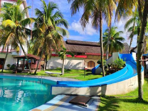 a resort with a swimming pool and palm trees at Hotel Wisata Indah Sibolga in Sibolga