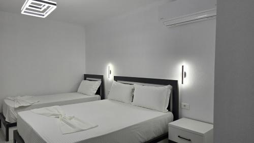 two beds in a room with white walls at Guest House Pogradeci in Pogradec