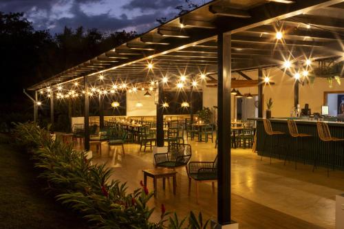 a patio with tables and chairs at night with lights at Natural Lodge Caño Negro in Caño Negro