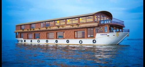 a building on a boat in the water at Marvelous Boathouse in Alleppey