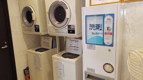 three washing machines and a washer and dryer in a room at Toyoko Inn Kobe Minatogawa Koen in Kobe