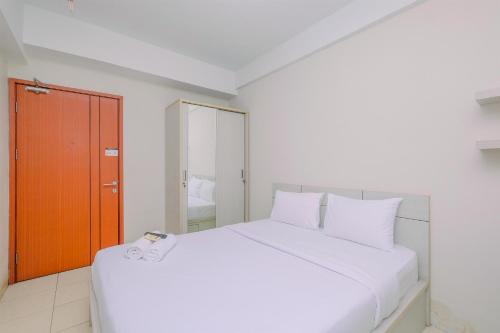 a white bed with white pillows in a room at Best Choice and Comfy Studio Apartment at Margonda Residence 4 By Travelio in Depok