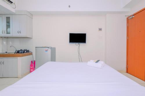 a room with a large white bed in a kitchen at Best Choice and Comfy Studio Apartment at Margonda Residence 4 By Travelio in Depok