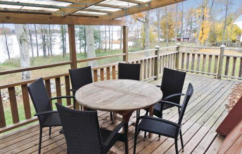 a wooden table and chairs on a deck at Stunning Home In Ljungby With Wifi in Bolmstad