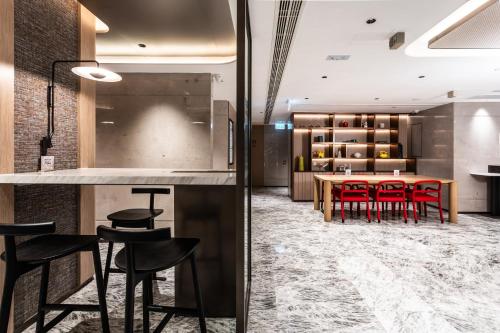 a dining room with a table and red chairs at Wharney Hotel in Hong Kong