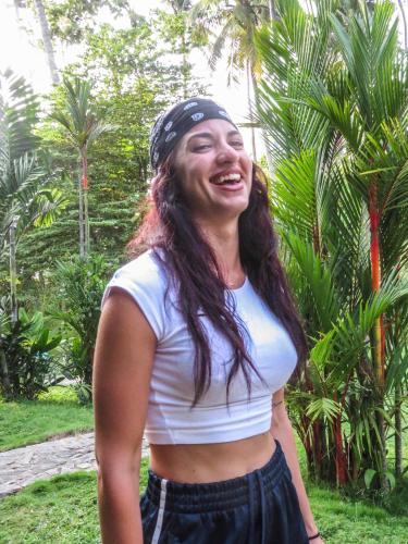 a woman wearing a bandanna on her head standing in front of trees at Hotel Riverrina in Negombo