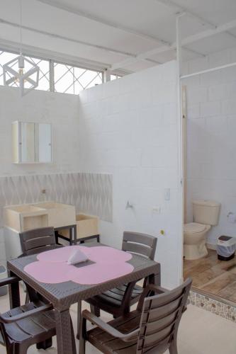 a table and chairs in a room with a toilet at Apartamento con buena ubicación PARA FAMILIA Grande in Cali