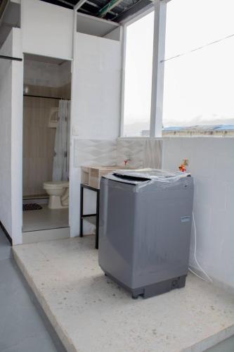 a room with a toilet and a large room with a machine at Apartamento con buena ubicación PARA FAMILIA Grande in Cali