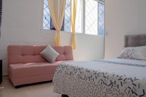 a bedroom with a pink couch and a bed at Apartamento con buena ubicación PARA FAMILIA Grande in Cali