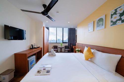 a hotel room with a bed and a tv at Quoc Cuong Hotel & Apartment Danang by Haviland in Da Nang