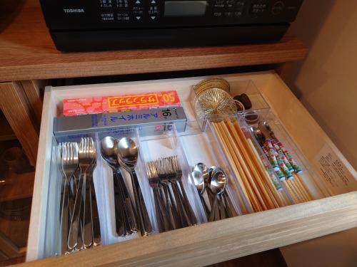 a drawer filled with utensils and spoons and forks at 川越の家夜風 小江戸観光に最適 川越市駅5分 庭付き新築一軒家 Bbq可 最大12名 駐車場2台小型車のみ in Kawagoe