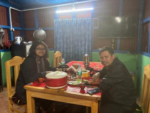 a man and a woman sitting at a table at Thupten Homestay, Dirang in Dirang Dzong