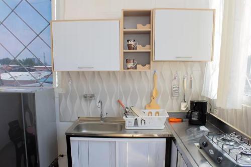 a kitchen with a sink and white cabinets at Apartamento con buena ubicación PARA FAMILIA Grande in Cali