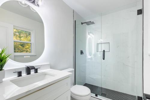 Un baño blanco con lavabo y ducha. en Cozy 3 Bedroom Haven, en Decatur