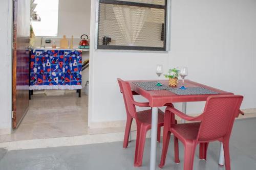 a red dining room table with two red chairs at Apartamento con buena ubicación PARA FAMILIA Grande in Cali