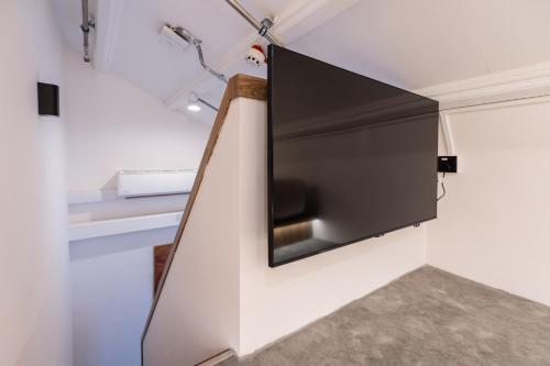 a television hanging on a wall in a room at Heritage Collection on Victoria - Mobile App Check-In in Singapore