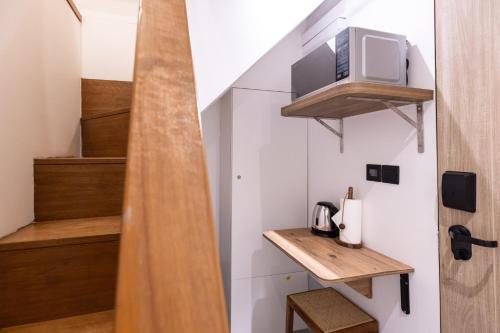 a room with stairs with a tv and wooden shelves at Heritage Collection on Victoria - Mobile App Check-In in Singapore