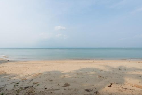 a sandy beach with the ocean in the background at Sun & Sand Bungalows in Thongsala