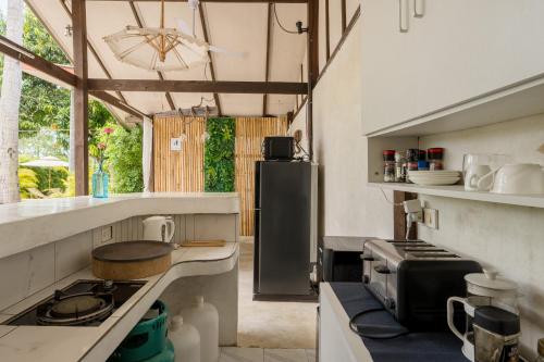 a kitchen with a stove and a refrigerator at Sun & Sand Bungalows in Thongsala