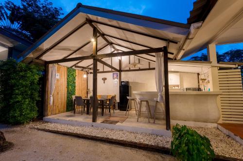 a patio with a table and chairs in a house at Sun & Sand Bungalows in Thongsala