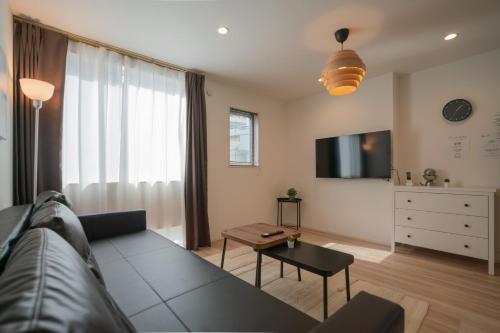 a living room with a couch and a tv at 静和 旅タイム寺田町 in Osaka