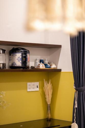 a shelf with a toaster and a vase on a table at Boho Boutique Da Lat - View nhà lồng lãng mạn in Da Thanh