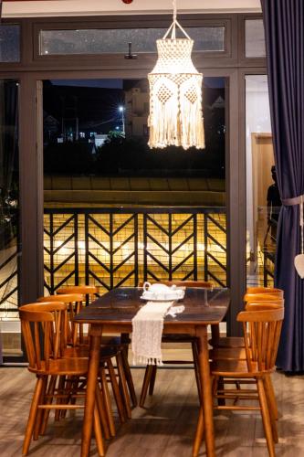 a dining room table with chairs and a chandelier at Boho Boutique Da Lat - View nhà lồng lãng mạn in Da Thanh