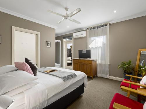 a bedroom with a bed and a flat screen tv at Athelstane Hotel in Queenscliff