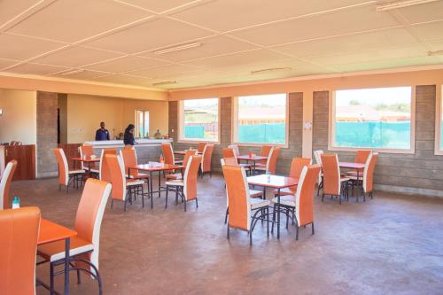 a dining room with tables and chairs and windows at Supastop Rest & Go in Sultan Hamud