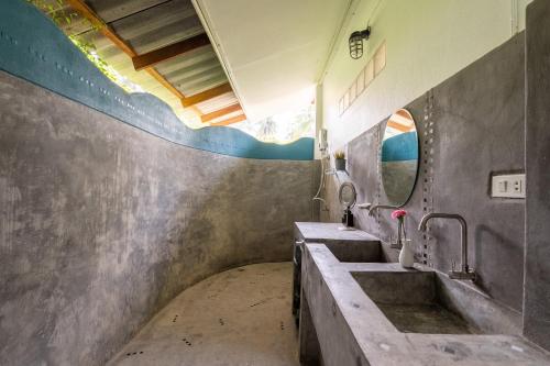 a bathroom with three sinks and a mirror at Sun & Sand Bungalows in Thongsala