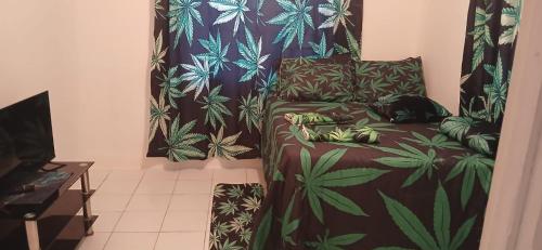a room with a couch with a plant themed curtain at Multiple air condition Rooms in Port Morant St Thomas Jamaica in Bowden